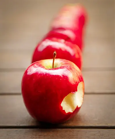 맨앞 붉은 사과에 한입 베어 물은 자국이 남아 있고, 그 사과 뒤로 일열로 여러개가 줄서 있다