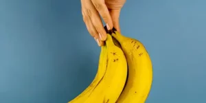 바나나 한송이를 손가락으로 들고 있는 모습